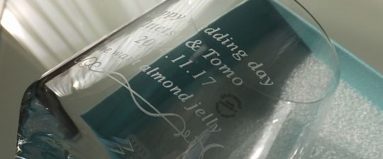 ティファニーのタンブラー側面に「Happy Wedding」の文字と新郎新婦のお名前、結婚記念日、そして心温まるお祝いのメッセージが美しく名入れ彫刻された結婚祝いのギフト写真