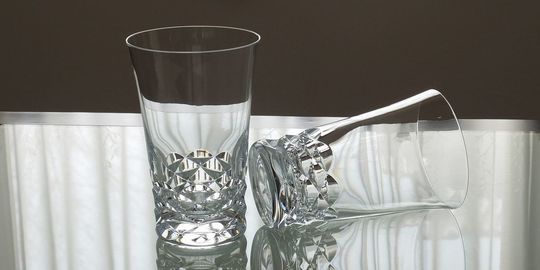 バカラのハイボールグラス、スウィングハイボールが2客テーブルの上に置いてある写真。扇型のなめらかな曲線が特徴の美しいクリスタルグラスが並び、光を反射して輝き、モダンで洗練された食卓の雰囲気を演出しています。