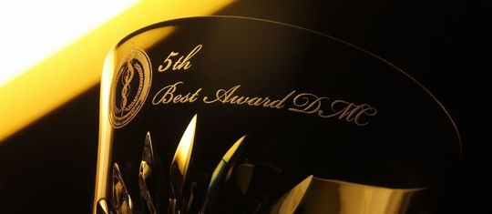 バカラのタンブラーの側面に、『5th Best Award DM』という文字とロゴデザインを名入れ彫刻した写真。高品質なクリスタルに刻まれた記念のメッセージとロゴが、受賞の喜びを特別な形で残し上品に輝いています。