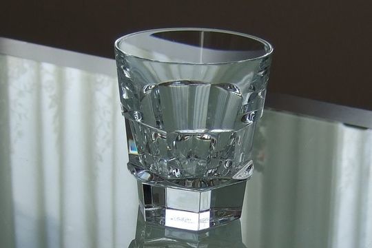 バカラのロックグラスがエレガントにテーブルの上に置かれた写真。洗練されたデザインが光を反射し、上質な空間を演出