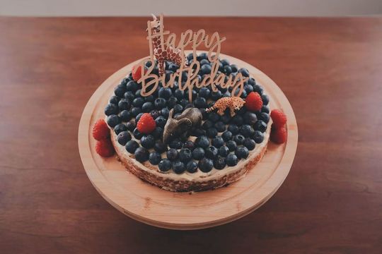 誕生日記念のホールケーキ ブルーベリーとラズベリーがたくさんのった『Happy Birthday』飾りのバースデーケーキ