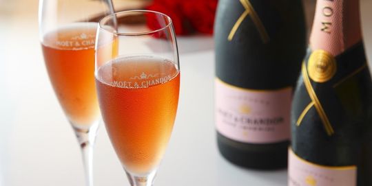 バカラのシャンパングラスの商品一覧ページのトップ写真。2つのバカラシャンパングラスと、2本のピンクのモエ・エ・シャンドンがテーブルの上に置かれています。クリスタルの輝きと、ロゼシャンパンの美しい色が組み合わさり、祝宴や特別な日の雰囲気を演出し、バカラのシャンパングラスが提供する優雅な瞬間を象徴しています。