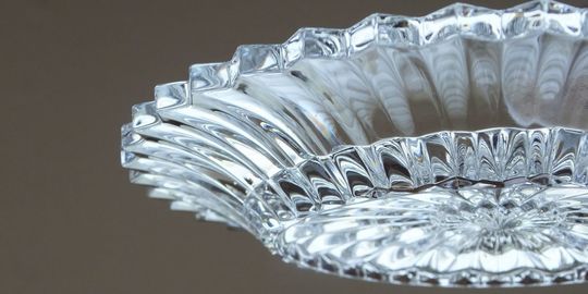 バカラのミルニュイプレートの美しいカットをアップにした写真。繊細なプリーツ状に施されたカットが、光を美しく屈折させ、ミルニュイ（千の夜）という名にふさわしい幻想的な輝きを放っています。バカラの高い技術力とデザイン性を際立たせた特別なギフトです。