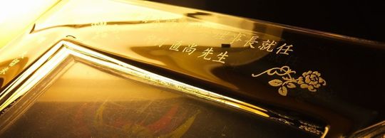 ウエッジウッド製フォトフレームに理事長就任祝いの名入れ彫刻とワンポイントのお花のデザインを施したオーダーメイド記念品」