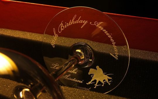 馬主の80歳の誕生日祝い、ジョッキーと競走馬のイラスト入り名入れ彫刻が施されたバカラワイングラス