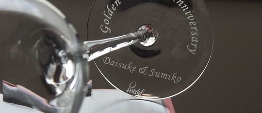 リーデル・ソムリエシリーズの底面に結婚50周年記念の名入れ彫刻を施した写真。特別な日のためにデザインされた高級感あふれるグラス、アニバーサリーにぴったりな思い出に残るギフト