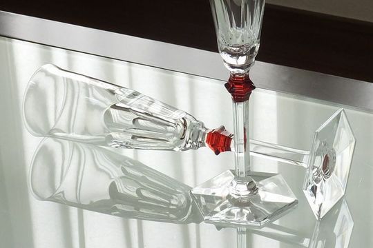 バカラのシャンパングラスが横向きに美しくテーブルの上に置かれ、クリスタルの輝きが光を反射し、豪華で洗練された空間を演出