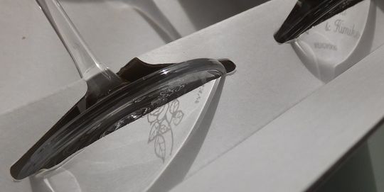 ウェッジウッド プロミシスウィズディスリングワイングラスの底面に『1st Wedding Anniversary』、お二人の名前、そしてバラのデザインが彫刻された写真。グラスが光を浴びて、彫刻が箱に美しく映り込んでいる様子が、特別な記念の輝きを表現しています。