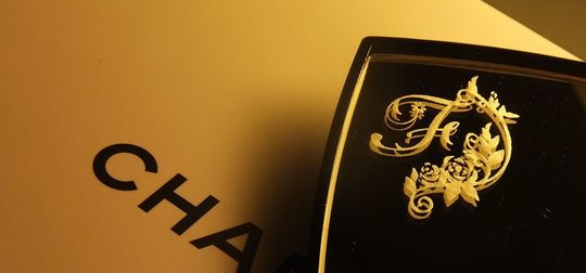 シャネルの名入れミラーに、美しいイニシャル【F】のデザインが彫刻された写真。エレガントで高級感あふれるオーダーメイドギフト。