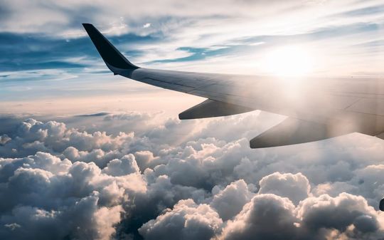 法人ギフトのトップを飾る、飛行機の窓から見た雲海と左翼の写真。まばゆい光が差し込み、未来への明るい展望と新たな旅立ちを象徴する光景