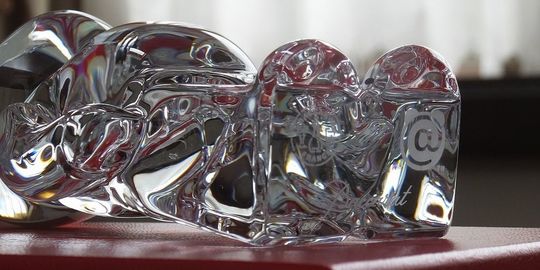 バカラのベアブリックの底面に、『Baccarat』の刻印とロゴマーク、そしてベアブリックのロゴマークが刻印されている写真。透明なクリスタルの底面に、それぞれのブランドロゴが繊細に刻まれ、製品の真正性と特別なコラボレーションを証明しています。