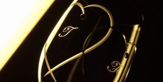 ウェッジウッド プロミシストゥーハーツワイングラスの側面にデザインされた二つのハートの中に、お二人のイニシャルを名入れ彫刻したアップ写真。繊細な彫刻のディテールと、特別な贈り物としてのパーソナルな魅力が際立っています。