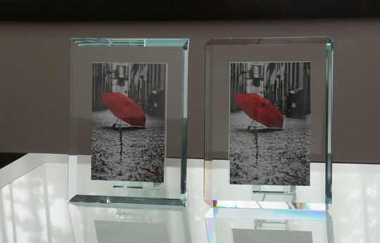 オモドモのタイプの違う2つのフォトフレームが、テーブルの上に置いてある写真。イタリアン製のエクストラクリアガラスフレームが、異なるカットやデザインで並べられています。大切な思い出を飾る特別なギフトにふさわしい逸品です。