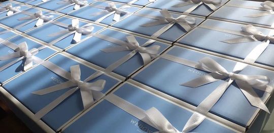 ウェッジウッド名入れ商品一覧ページ：ウェッジウッドブルーの箱に白いリボンが美しく結ばれたギフトボックスが多数並べられた写真。贈り物としての特別感と、ブランドの上質さを伝えます。