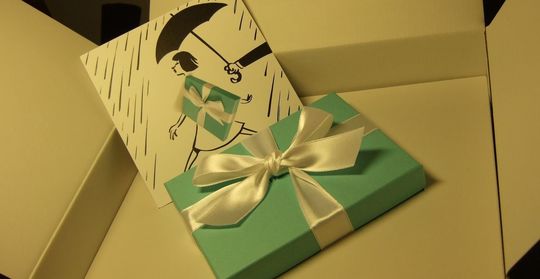 箱を開けると、ティファニーブルーボックスがぴったりと穴にはまっている、サプライズ演出配送の開封時の写真。大切な方への贈り物が、特別な体験と共に届く喜びを表現しています。