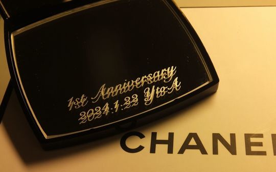 結婚1周年記念の贈り物として、シャネルのコンパクトミラーに「1st Anniversary」、記念日、そして「Y to A」のイニシャルが美しく名入れ彫刻された写真