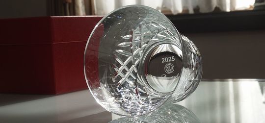 バカラのイヤーグラス〈アリア2025タンブラー〉を底に倒し、底面の名入れ彫刻位置を確認できる写真。2025の西暦とバカラロゴの刻印位置を明示し、名入れスペースの参考に