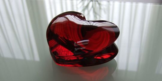 バカラの招き猫 クリアMサイズがテーブルの上に置いてある写真。透明なクリスタル製の招き猫が、その美しいフォルムと光の反射で、空間に幸運と洗練された雰囲気をもたらしています。名入れギフトとしても、インテリアとしても魅力的な逸品です。