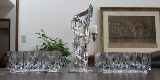 リビングのテーブルに、バカラのルクソールトレイ2個が並べられ、その間にスパイラルベースの一輪挿しが置かれた写真。バカラ製品が空間に優雅さと洗練された輝きを添える、美しいインテリアコーディネートです。