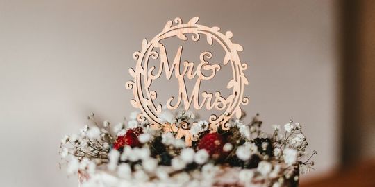ウェディングケーキに、木で作られた『Mr&Mrs』のケーキトッパーが乗っている写真。シンプルながらも温かみのあるデザインで、ケーキをより一層引き立て、二人の門出を祝う特別な雰囲気を演出しています。