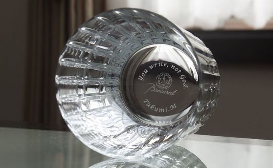 バカラグラスのハーモニータンブラーの底面に、『You write, not Got 名前』を名入れ彫刻した写真。繊細なカットが施されたクリスタルの底面に、心に残るメッセージと名前が美しく刻まれ、パーソナルな想いが伝わる特別なギフトとしての価値を高めています。