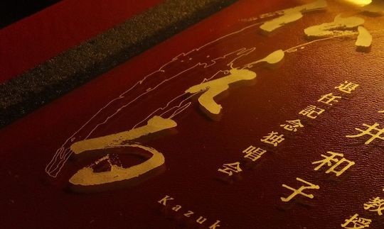 退職・退任記念に贈る名入れフォトフレーム バカラ アビスに音楽大学教授の退任記念独唱会と自筆の『伝える』の文字、学校名、お名前を彫刻