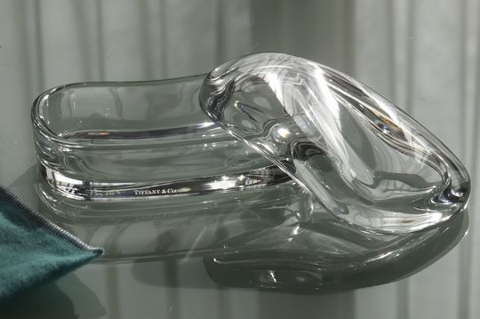 ティファニーエルサペレッティのウェーブボックスが洗練されたデザインでテーブルの上に置かれ、光を反射してエレガントな雰囲気を醸し出している