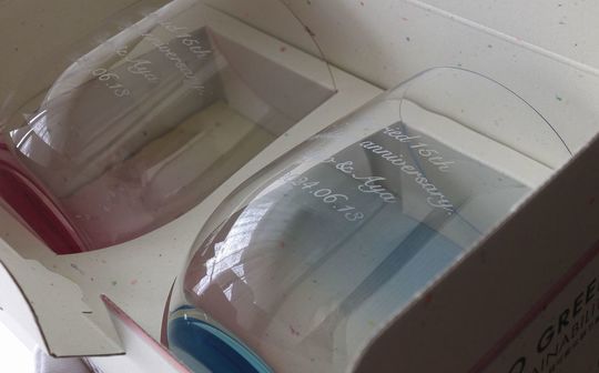 ティファニー ホームエッセンシャル シャンパンフルートの底面に、Happy Weddingをアーチ状に、2人の名前を直線で名入れ彫刻した結婚祝いギフトの写真