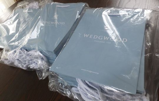 ウエッジウッドのブランドショッパーがセットごとにビニール袋で丁寧に梱包され、大量に並んだ写真 高級ギフト対応の包装資材準備・大量注文事例