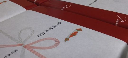 バカラのレッドボックス包装に創立70周年記念の熨斗をかけた、特別な記念品の贈答用ラッピング