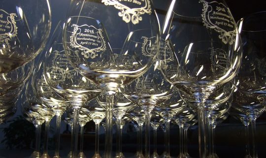 20周年記念として、リーデルのワイングラスがテーブルに並び、側面にオリジナルメッセージの名入れ彫刻が施された写真