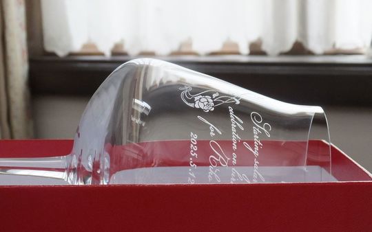 シャトーバカラワイングラスの側面に、誕生日祝いのメッセージ、日付、フラワーデザインを名入れ彫刻した写真。グラスはレッドボックスに収められており、高品質なクリスタルに刻まれた美しいデザインと、バカラの象徴的なパッケージが、特別な誕生日プレゼントとしての喜びを一層引き立てています。