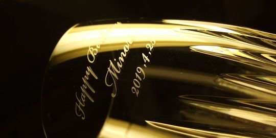 バカラのハイボールグラス、マッセナハイボールグラスの側面に、『Happy Birthday 名前 日付』をスクリプト体で名入れ彫刻したアップ写真。重厚感のある美しいカットが施されたグラスに、手書き風の優雅な書体で誕生日を祝うメッセージが丁寧に刻まれています。