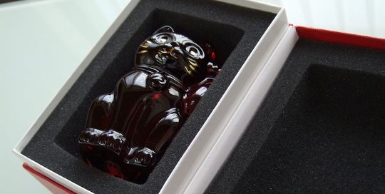 バカラの招き猫 レッドSサイズがレッドボックスに入っている写真。情熱的な赤いクリスタル製の招き猫が、バカラの象徴的な赤い箱に収められ、贈り物としての高級感と特別感を際立たせています。