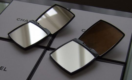 シャネルの特別仕様ギフトボックスの上に、開いた2つのコンパクトミラーが並ぶ高級感ある商品紹介写真。上品で贈り物に最適な名入れ対応アイテム。