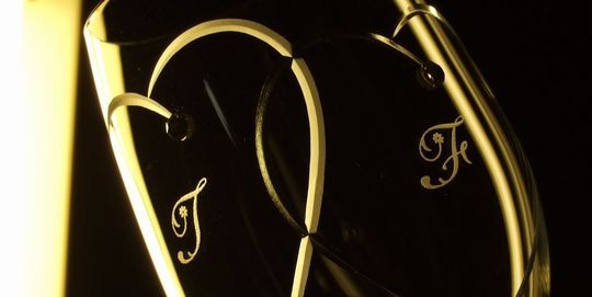 ウエッジウッドのプロミシストゥーハーツワイングラスに、２つのハートが重なるカットの中に新郎新婦のイニシャルを名入れ彫刻した特別な結婚祝いのギフト。愛の象徴であるハートとイニシャルが、結婚の絆を深める美しいデザイン