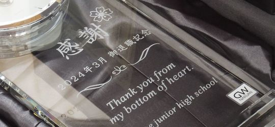 名入れ彫刻入りのガラス製振り子時計。グラスワークスナルミのセレナペンドラムクロックに、桜のデザインと退職記念メッセージを刻印