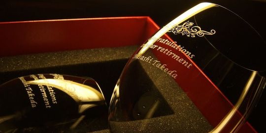 名入れ彫刻されたバカラのオノロジーボルドー。バラのデザインと“Congratulations on your retirement”のメッセージ入り退職祝いグラス