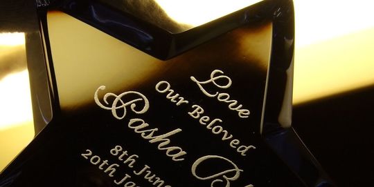 バカラのザンザンスター ミッドナイトに、ペットの遺影として名入れ彫刻した写真。深い青色のクリスタルで象られた星のオブジェに、大切な家族であるペットへの想いと名前が繊細に刻まれ、故ペットを偲ぶ美しい記念品としての価値と、深い愛情を表現しています。