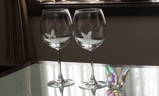 「バカラ製ワイングラスの側面に長年研究した2種類の蝶を名入れ彫刻したオーダーメイドギフト。特別な記念品