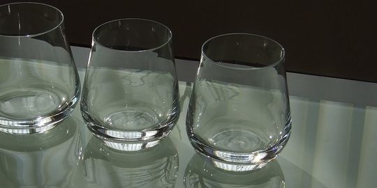 バカラのタンブラー（ロックグラス）の名入れページの商品一覧で使用する写真。バカラ シャトータンブラーSのペアグラスがテーブルの上に置かれています。丸みを帯びた美しいフォルムと、光を反射して輝くクリスタルが、ペアギフトとしての優雅さと特別感を演出しています。